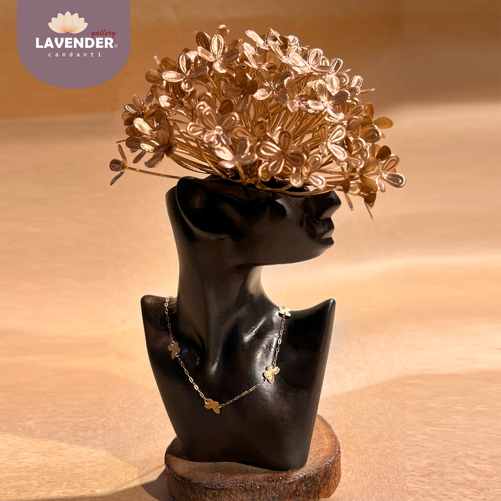 Gold floral headpiece on a black mannequin bust 