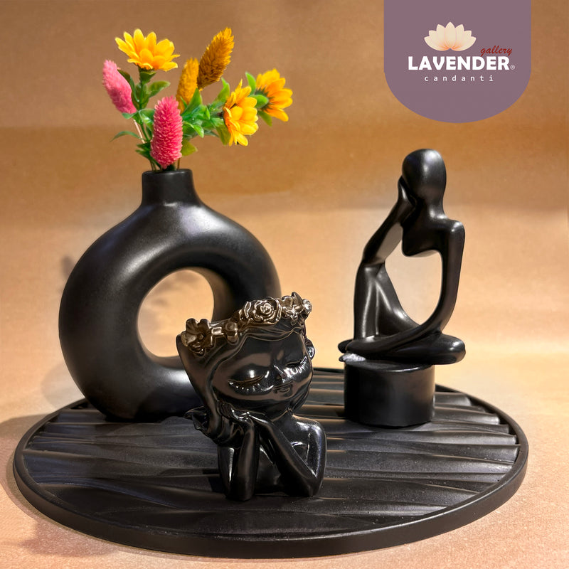 Decorative set with black sculptures and a vase with flowers 