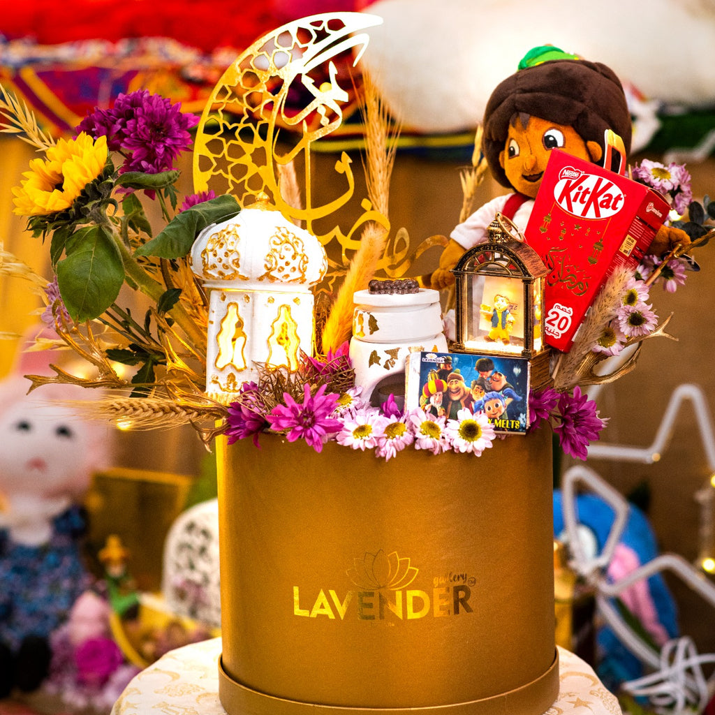 Decorative gift box with flowers, lanterns, and a toy on a table.