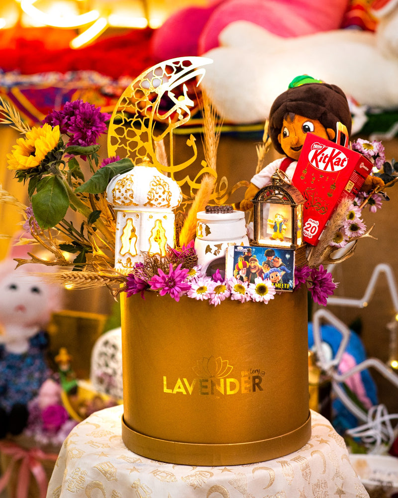 Decorative gift box with flowers, lanterns, and a toy on a table.