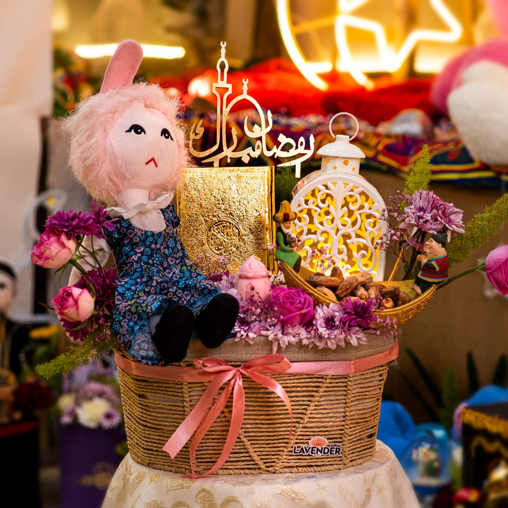 Decorative basket with plush toy, flowers, and lanterns on a table.