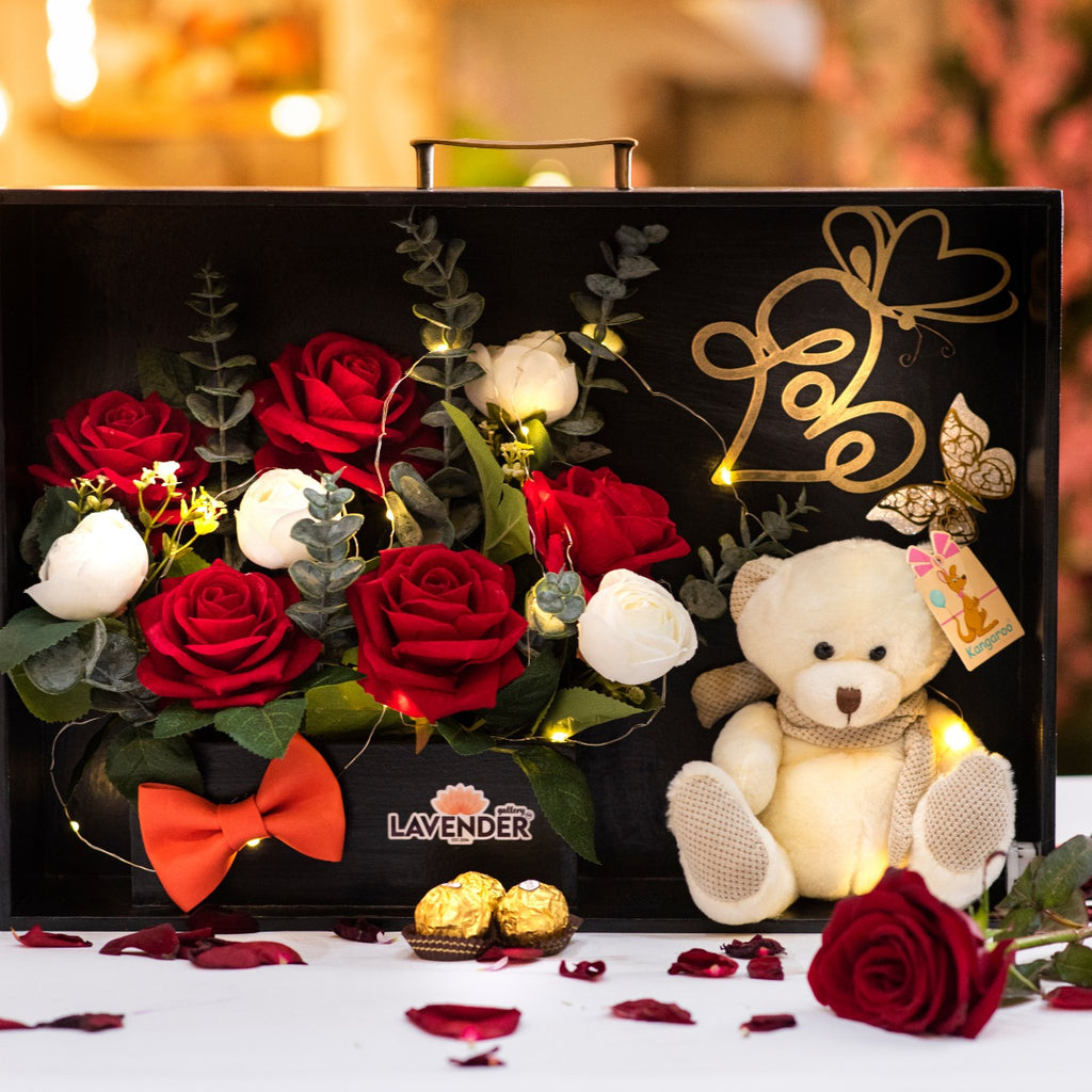 Gift set with teddy bear, roses, and 'LAVENDER' branding on a decorative background.